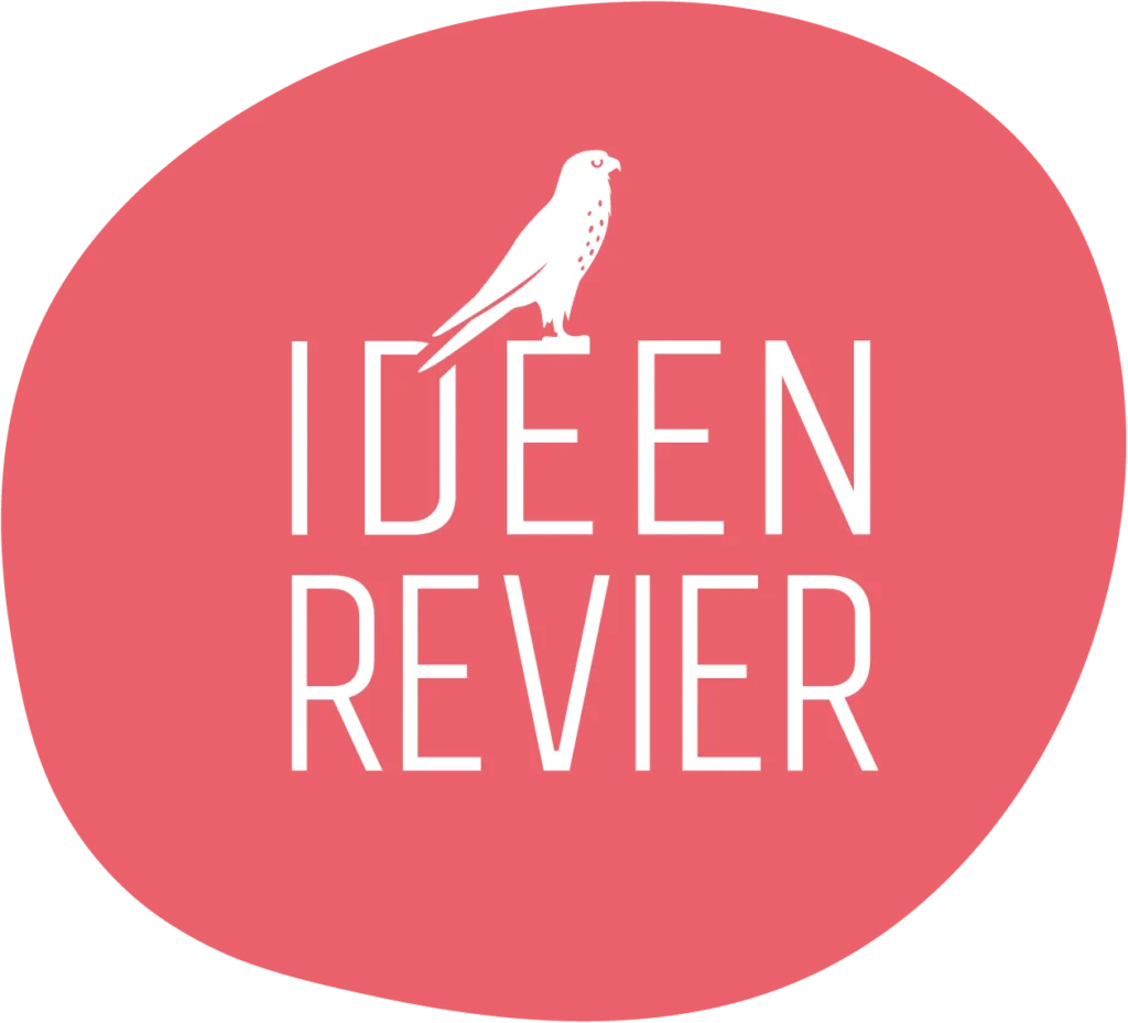 Weißes Ideenrevier Logo auf rotem Kreis. Falke auf dem ersten E von Ideen sitzend